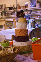 Cheese tower of different cheese rounds mounting from large to small, to celebrate the birthday of Ruth Hartley, mother, artist and author.