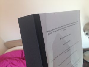 An very thick A4 sized thesis bound with black along the spine and with clear acetate over the title page. 